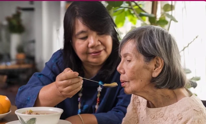 Caregiver sharing a meal at the kitchen table with a client