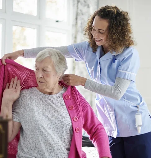 Beteli caregiver helping a client get dressed at home